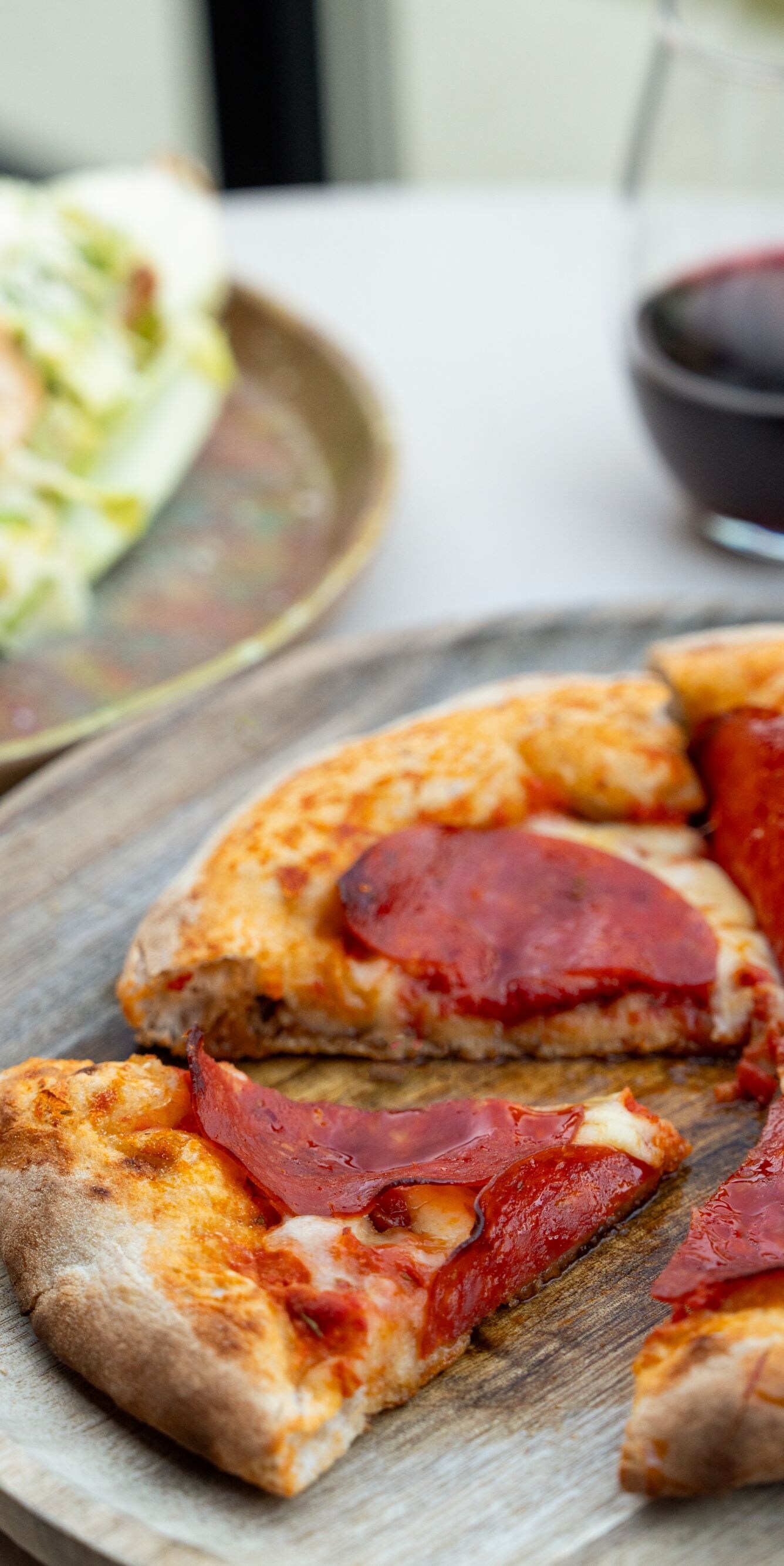 Pepperoni pizza with salad and red wine