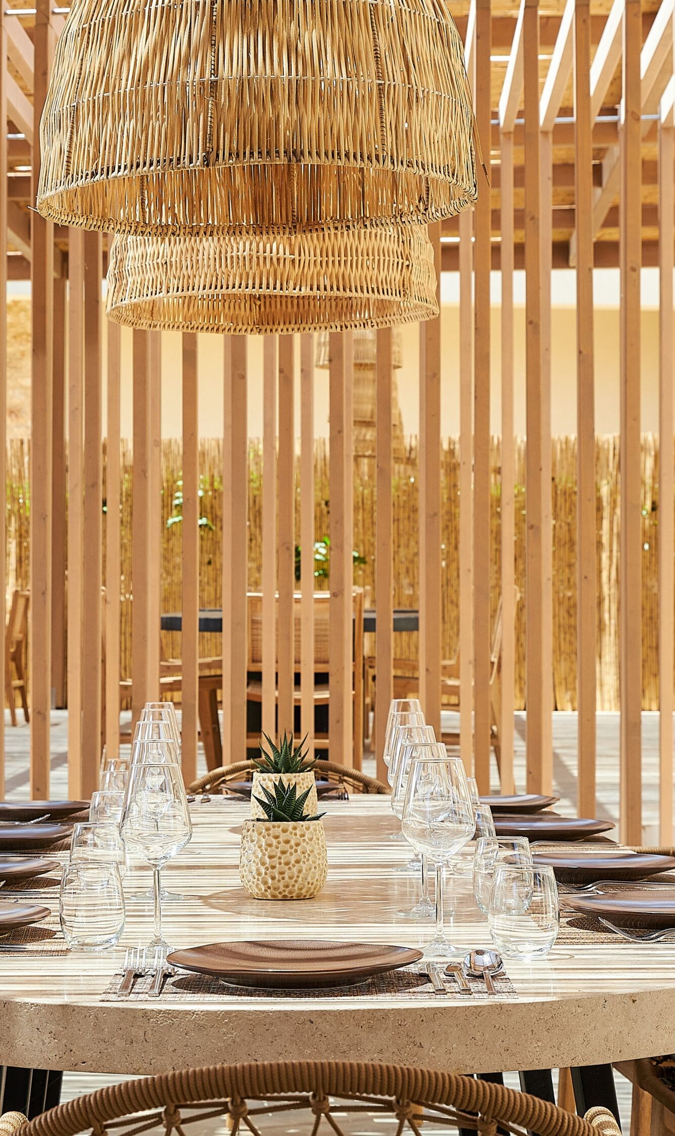 Restaurante al aire libre con pérgola de madera y cestas.