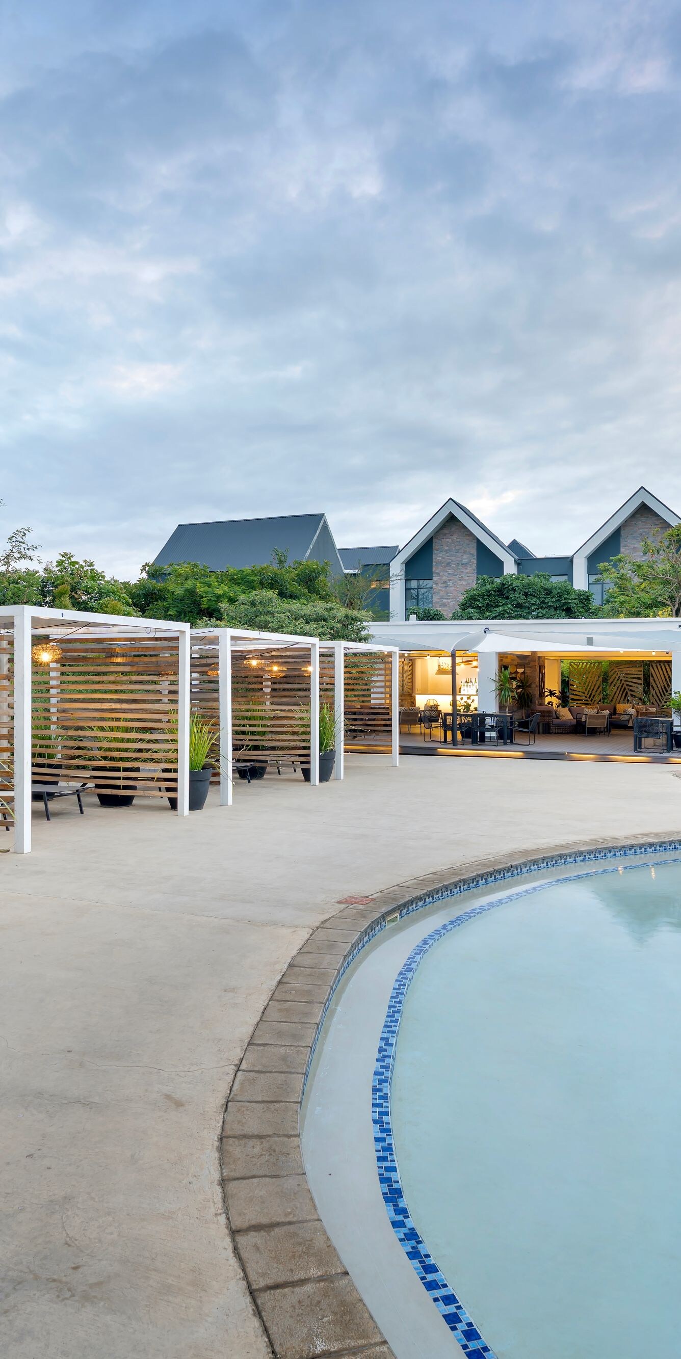 Curved pool with cabanas and seating area