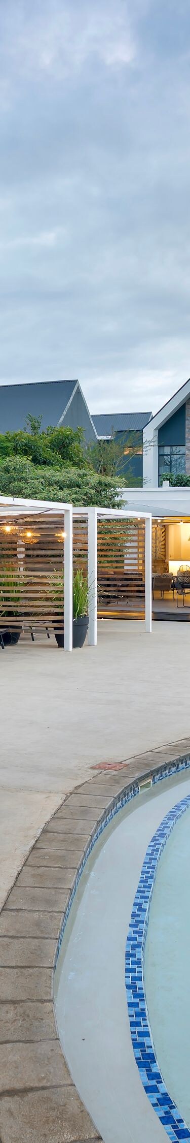 Curved pool with cabanas and seating area