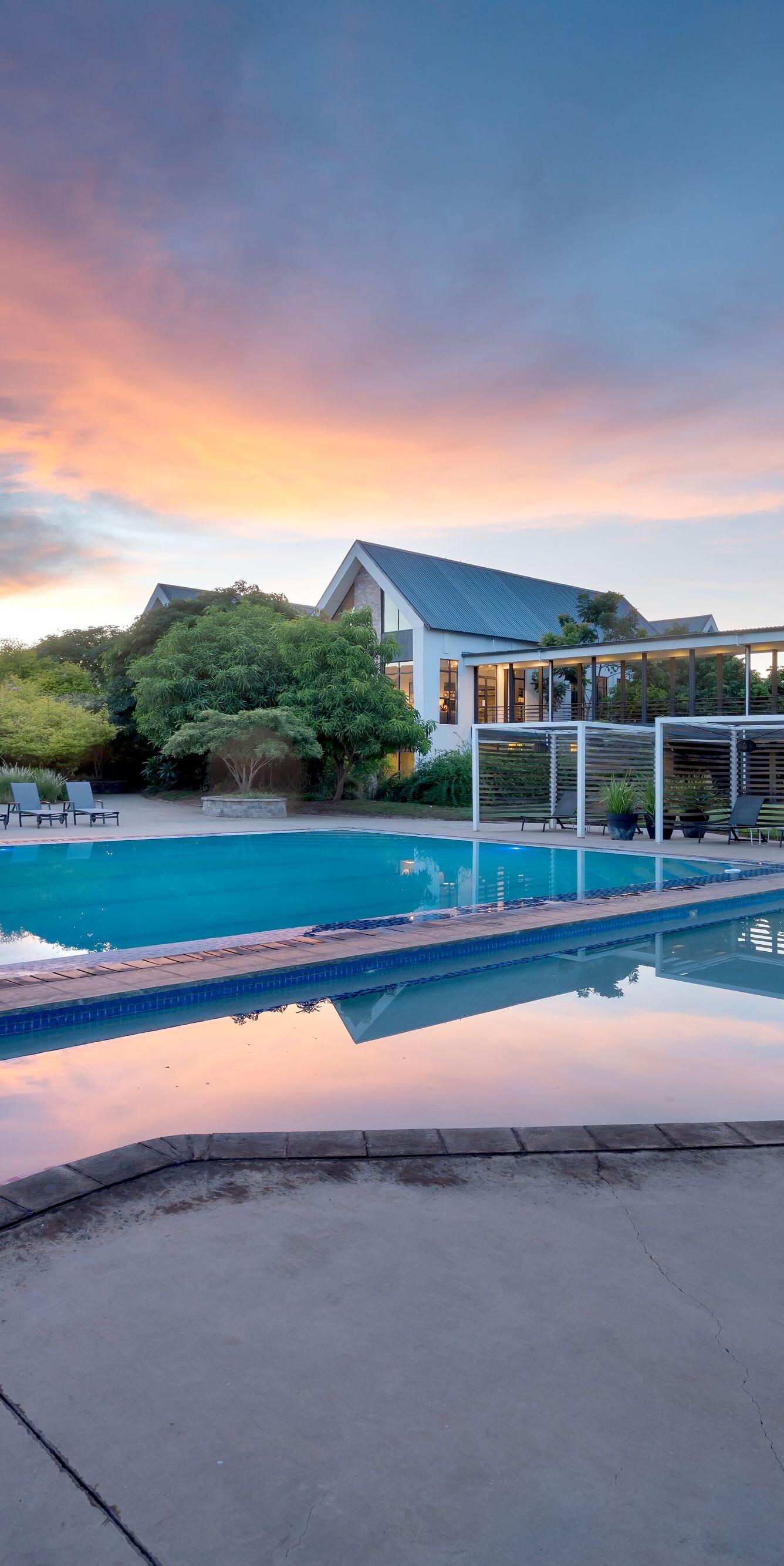 Resort pool at sunset with lounge chairs