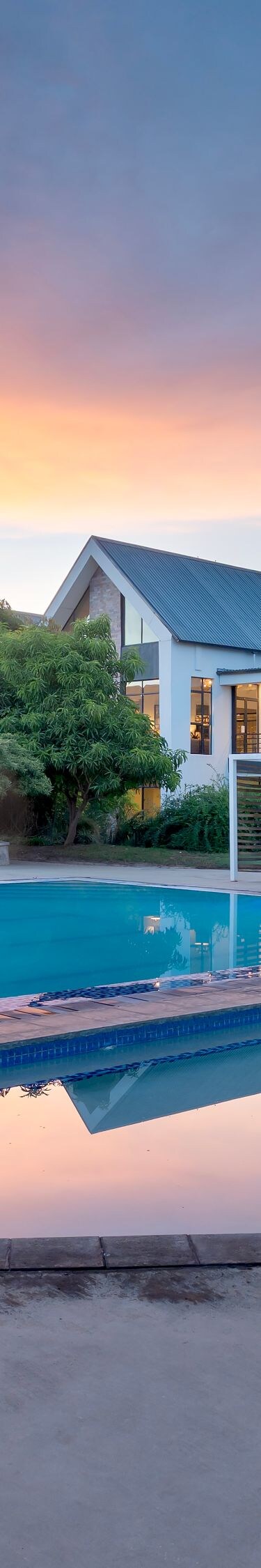 Resort pool at sunset with lounge chairs