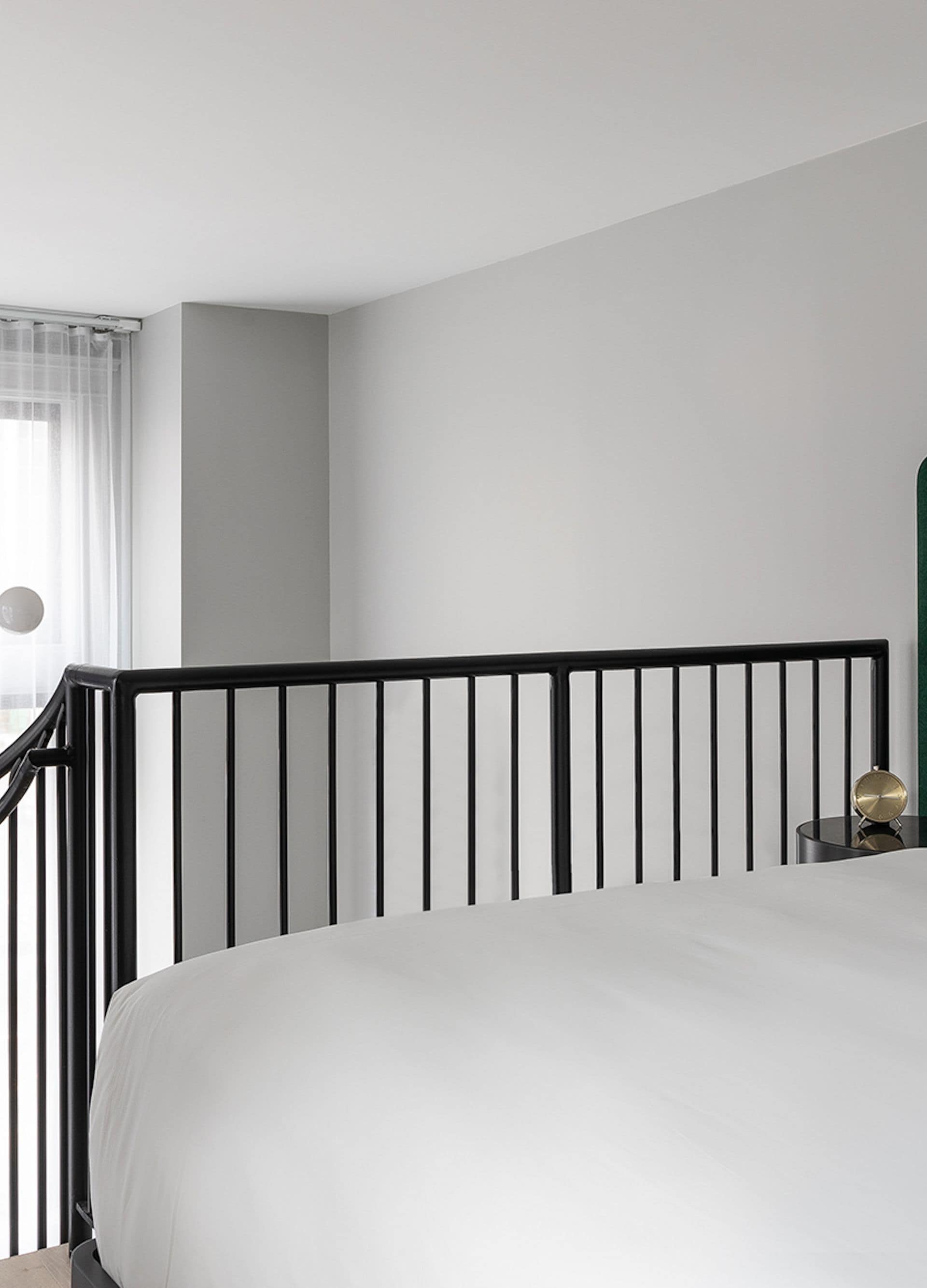 bed next to railing in a loft