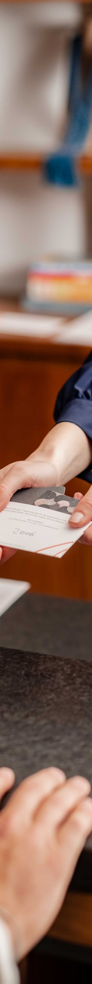 agent handing room key to guest at front desk