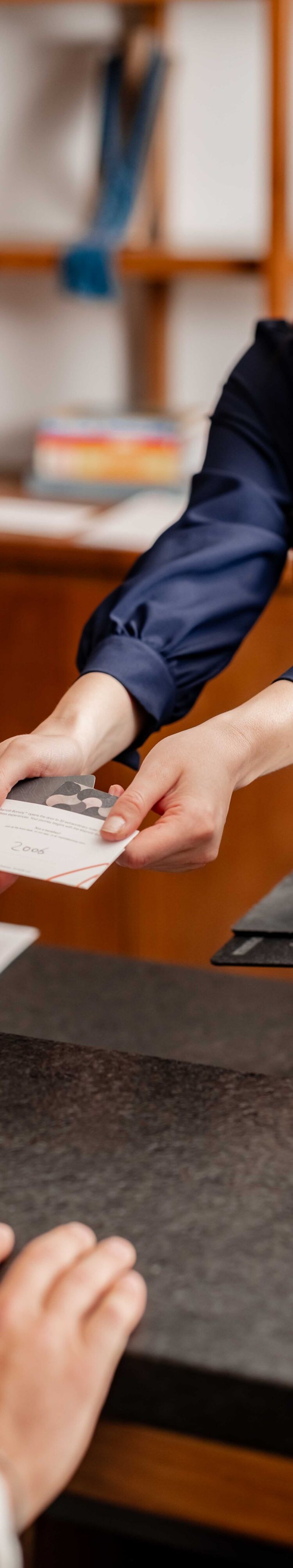 agent handing room key to guest at front desk