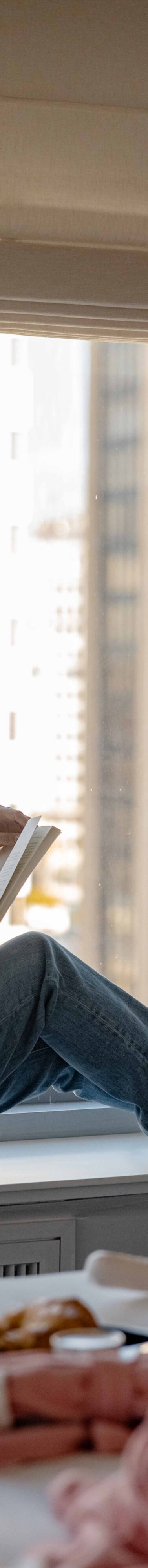 woman reading in a guest room window