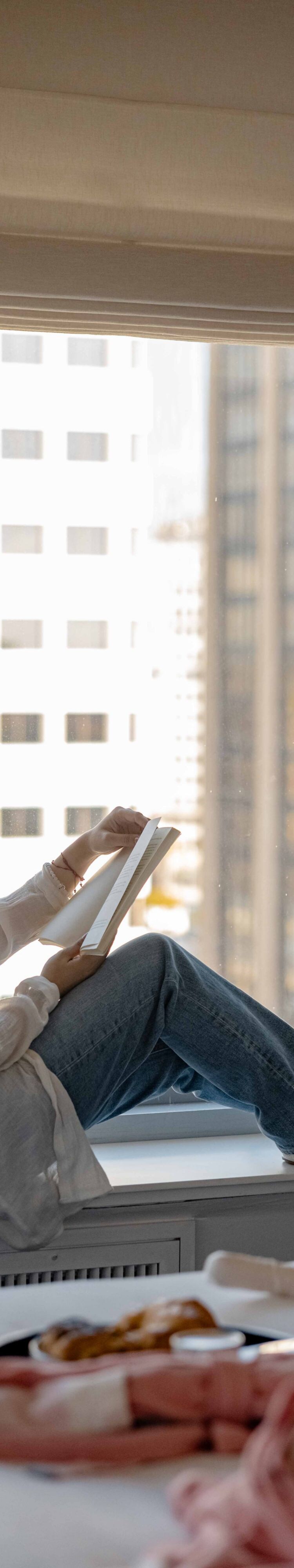 woman reading in a guest room window