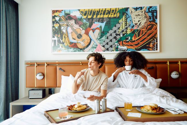 Man and woman eating breakfast in bed. 