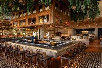 U-Shaped bar with greenery hanging from ceiling.