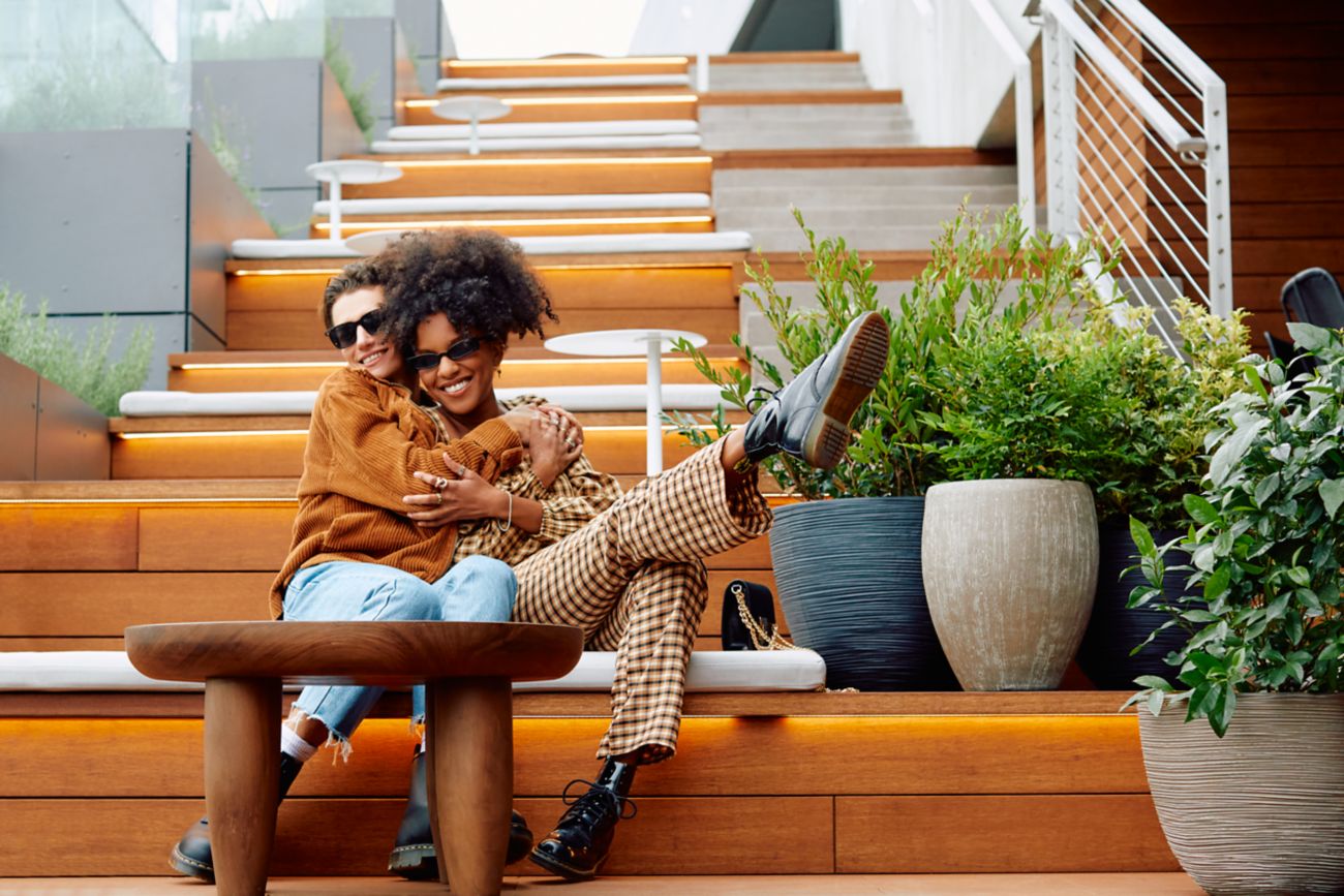 Two people hugging on outdoor stairs.