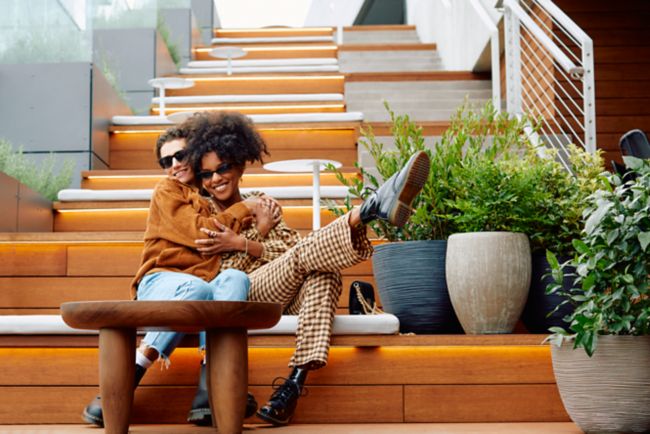 Two people hugging on outdoor stairs.