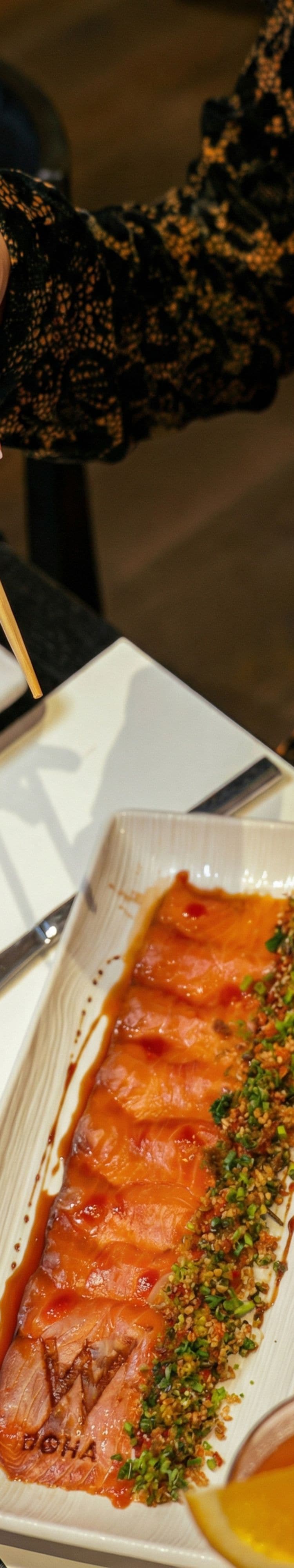 Guest enjoying a salmon dish with chopsticks