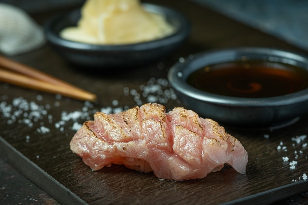 A piece of seared tuna belly sushi.