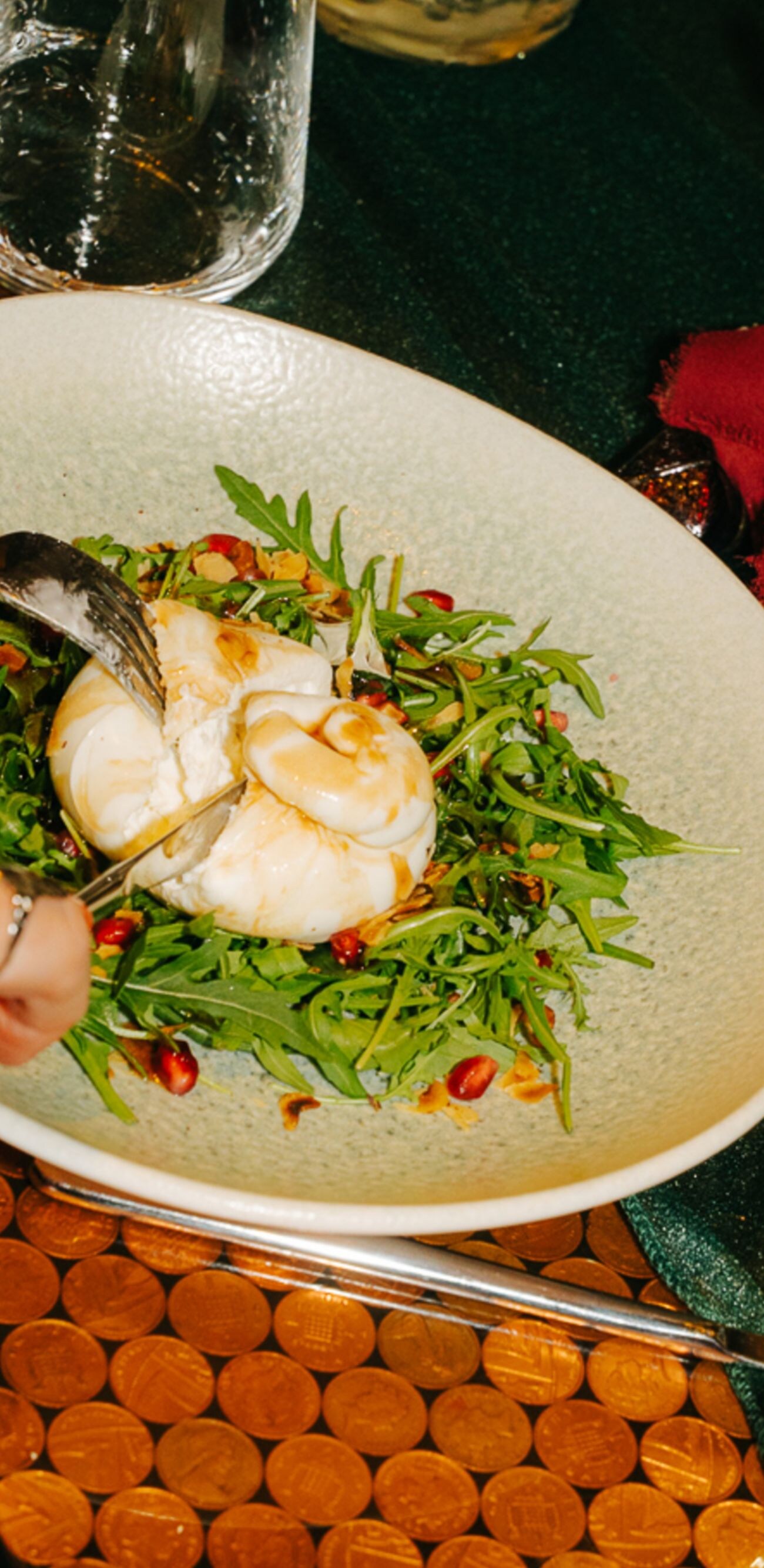 Person cutting burrata with champagne
