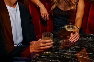 two hands holding wine glasses
