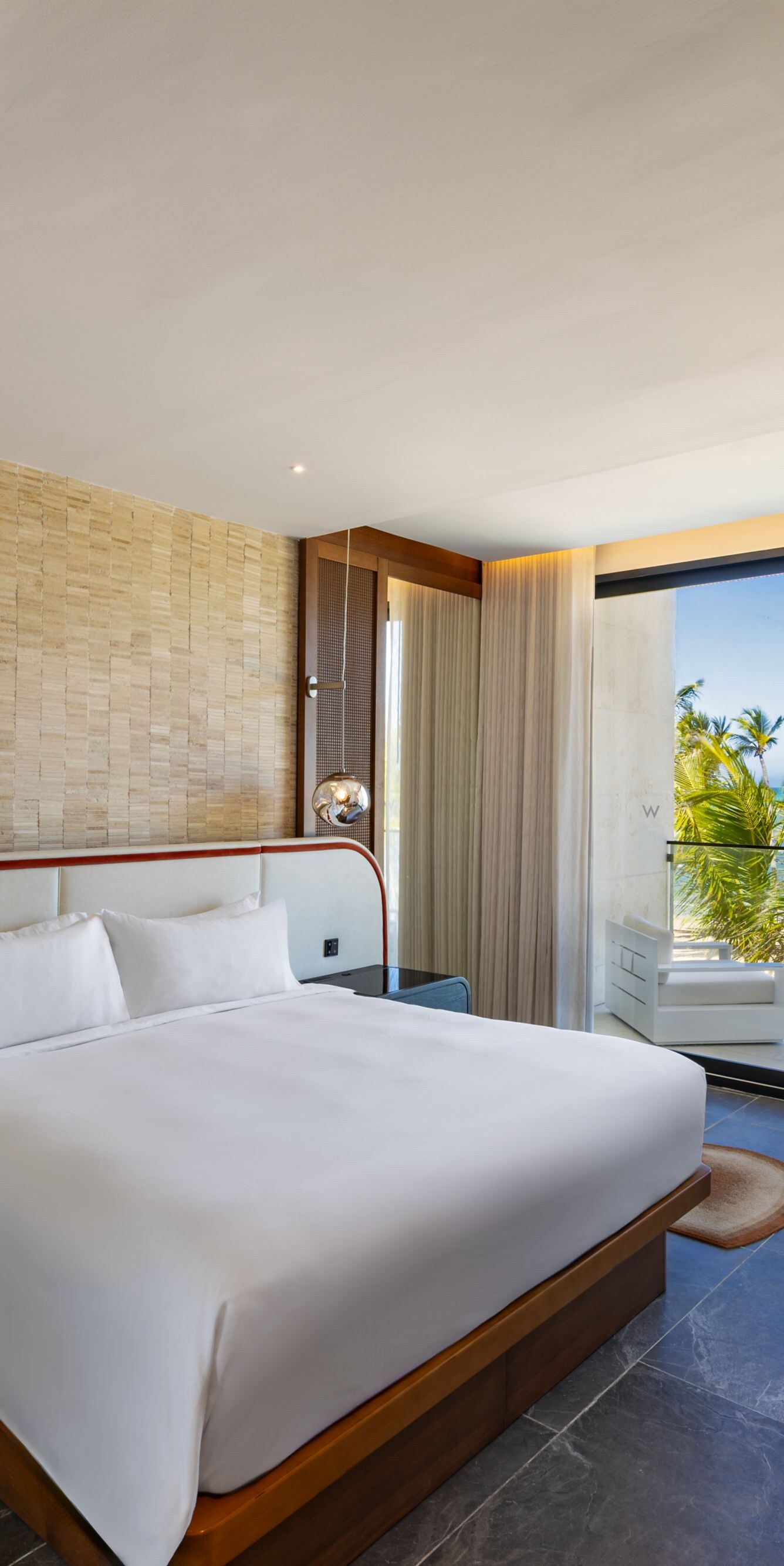 Cama tamaño King del dormitorio de la suite Oasis, vista al mar