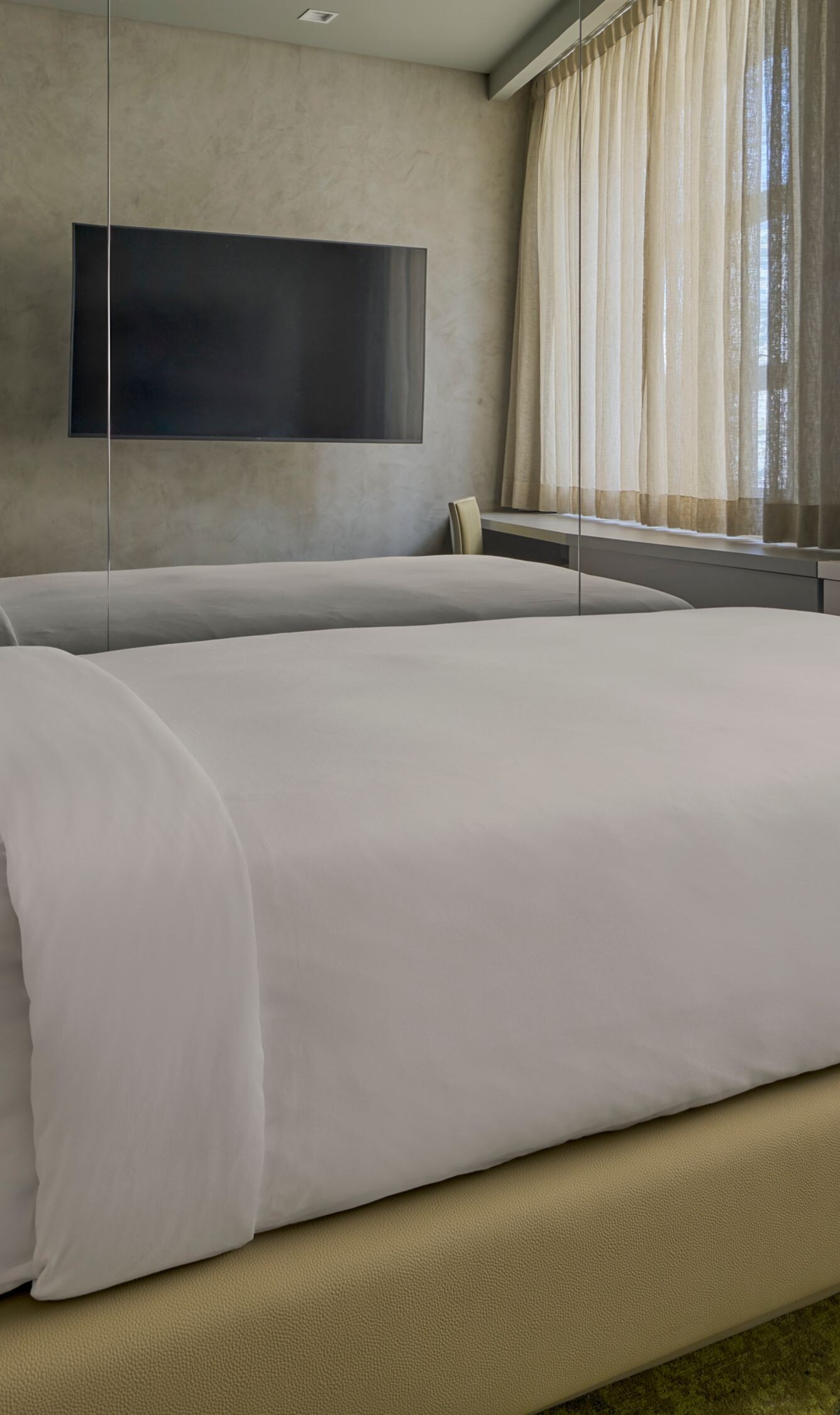 Bedroom with twin bed and desk, a TV and curtains