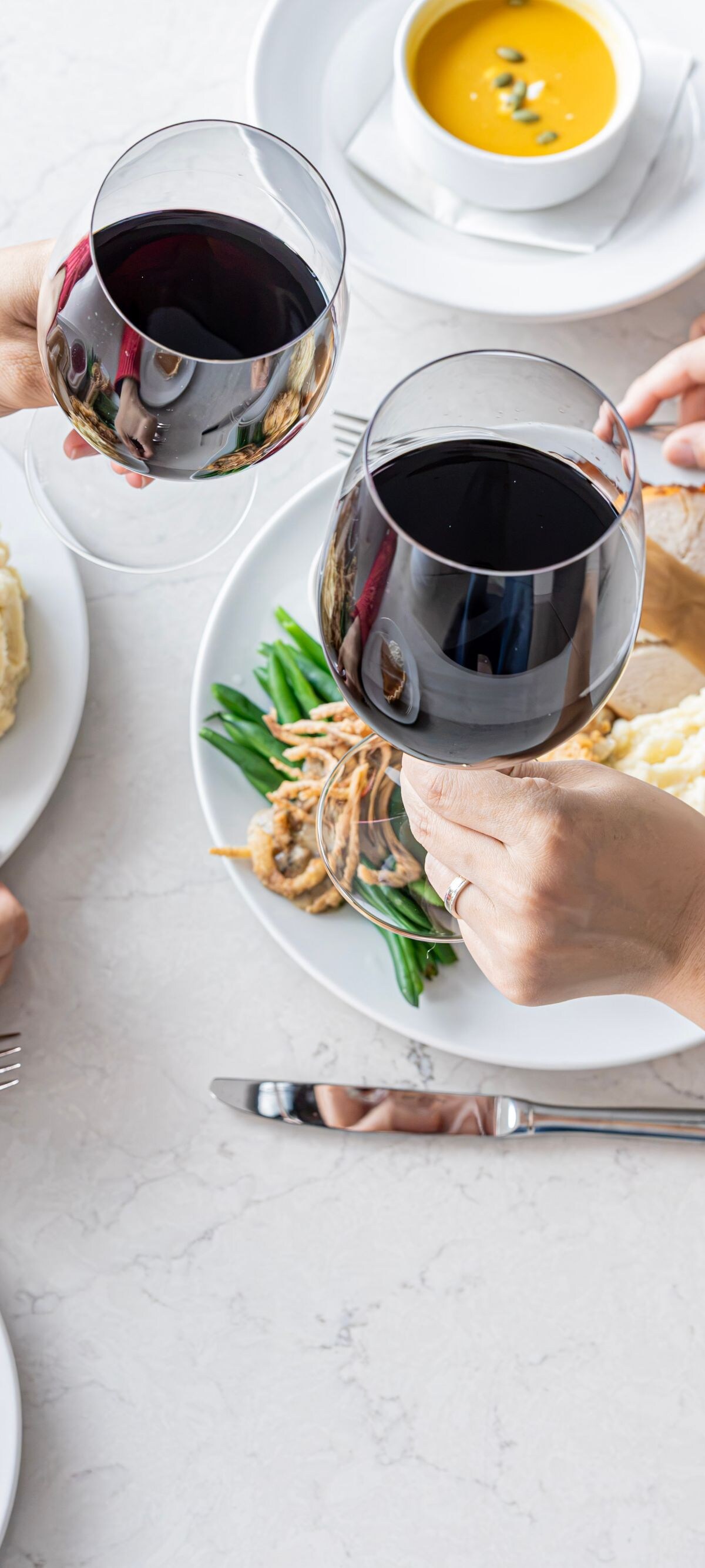 Two people toasting with red wine