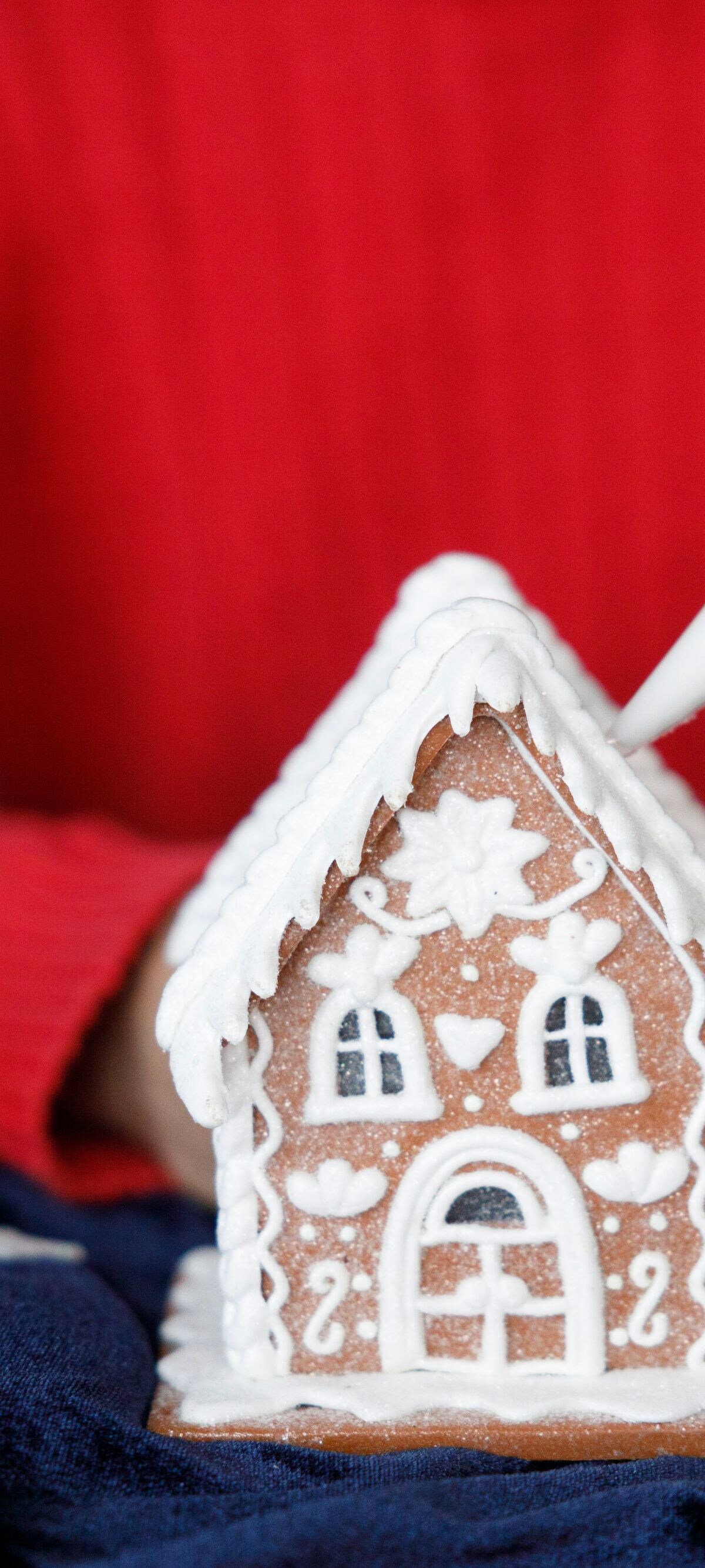 Person decorating gingerbread house