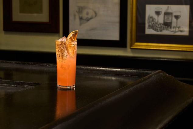 Orange cocktail in a tall drink glass with tajin r