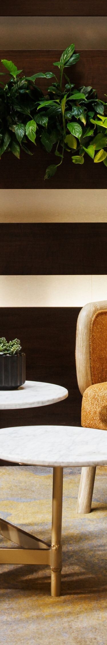 Lounge chairs beside living plant wall