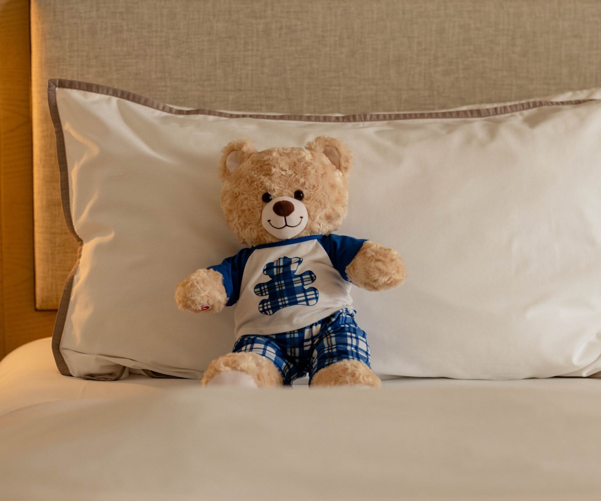 Teddy bear on hotel bed