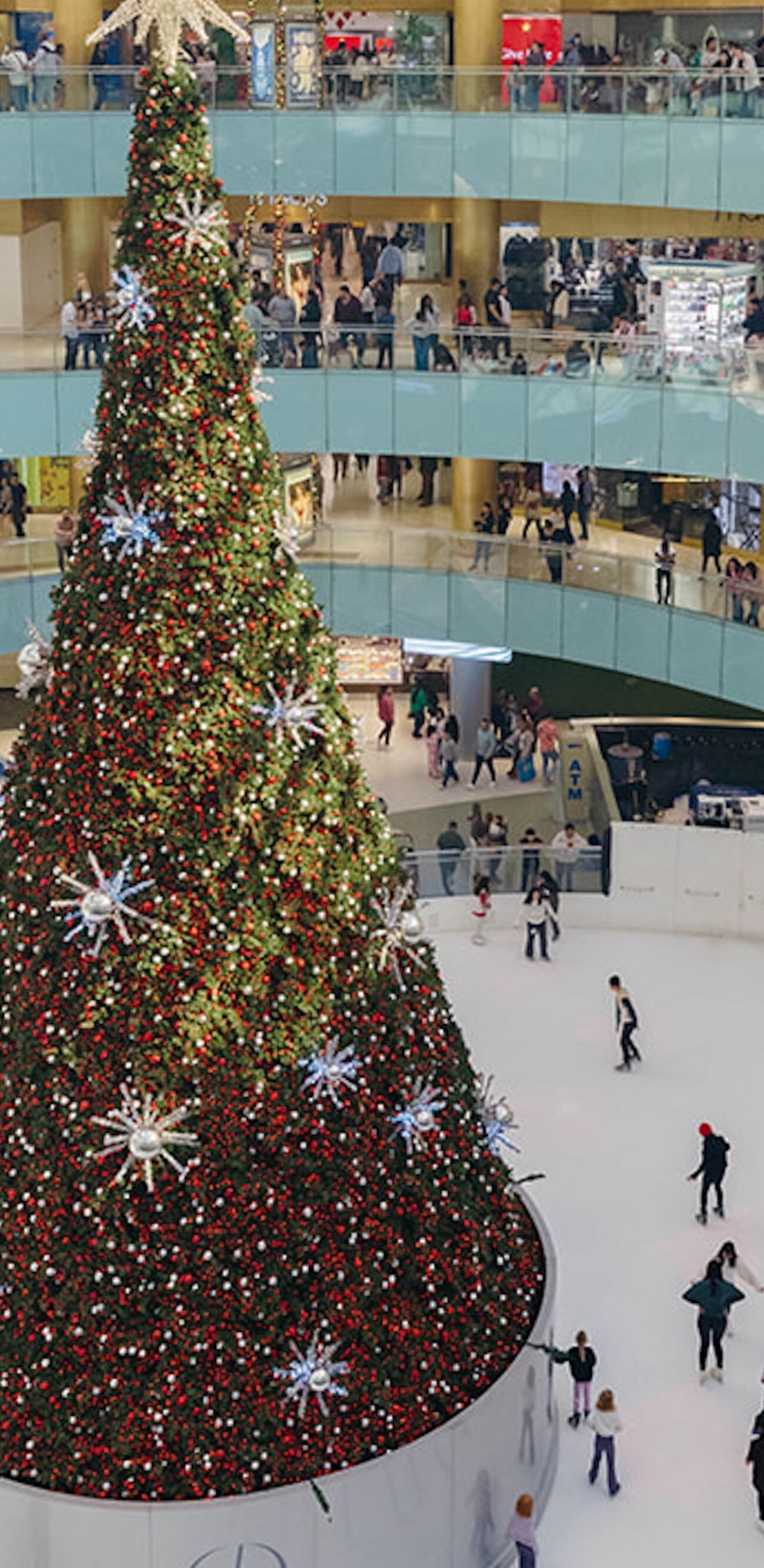Un árbol de Navidad alto con patinadores sobre hielo en Galleria Dallas