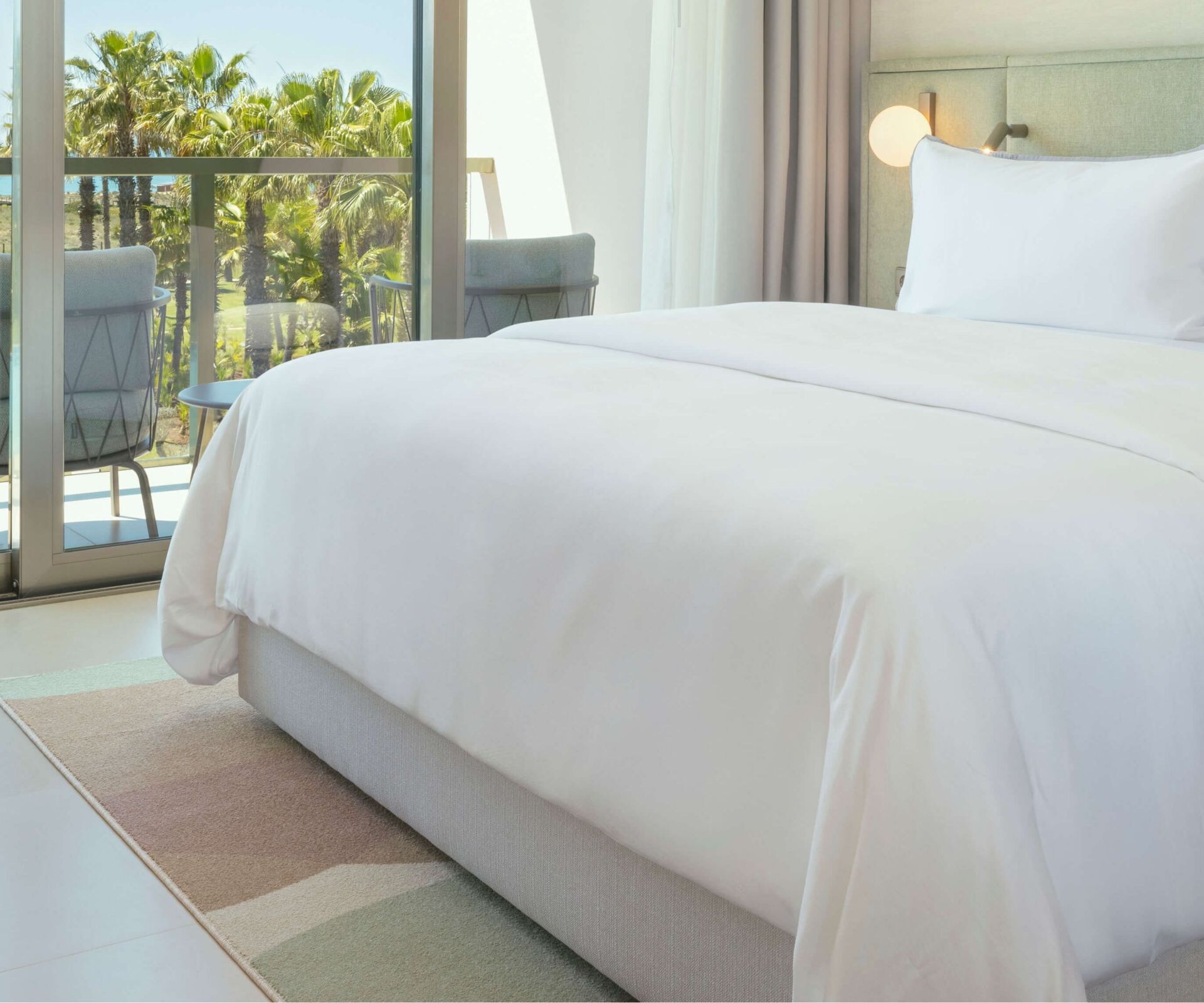 Hotel bedroom with sea view through balcony doors