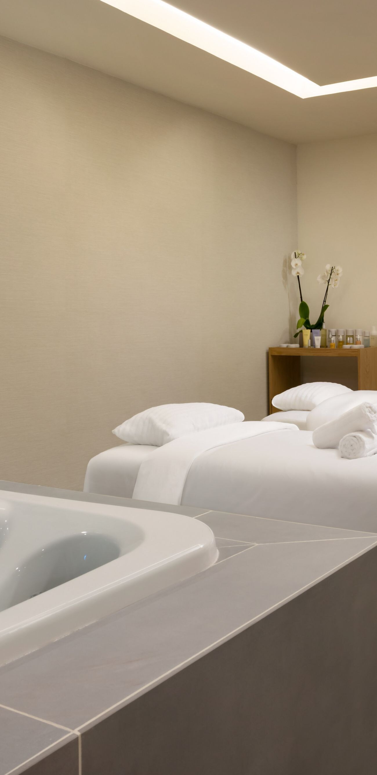 Sala de tratamento para casais com camas de spa e banheira de hidromassagem 