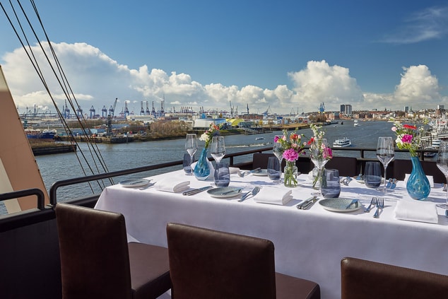 Dining table on balcony with view on harbor