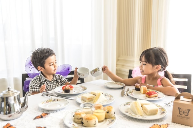 Two children having tea and pastries