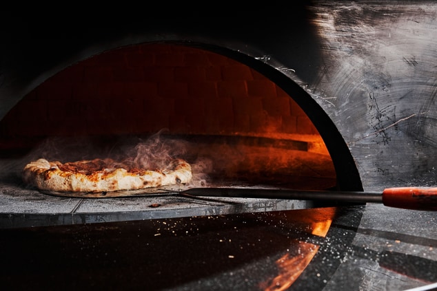 Pizza going into brick oven