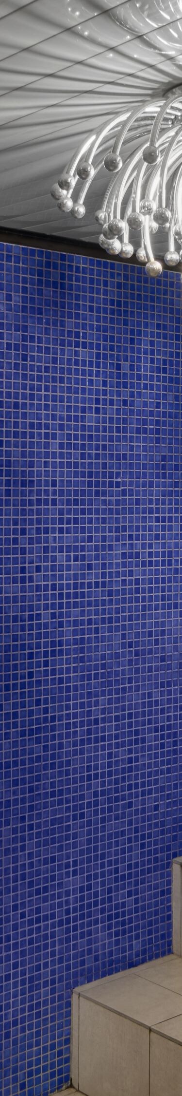 Indoor pool with blue tiles and chandelier