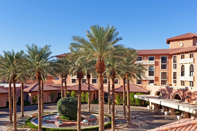hotel entrance with palm trees and blue skies