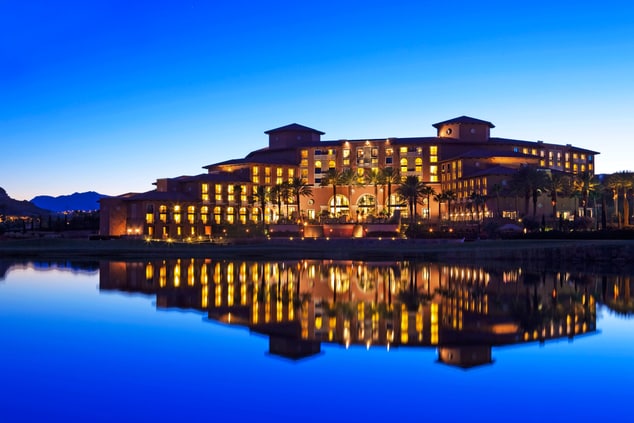 resort hotel at night with reflection off a lake