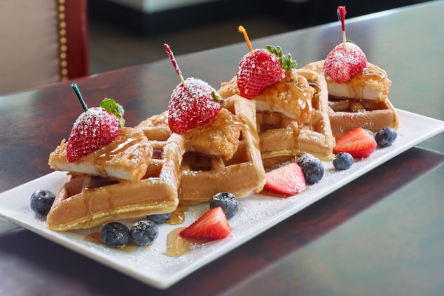 chicken and waffles dish topped with strawberries