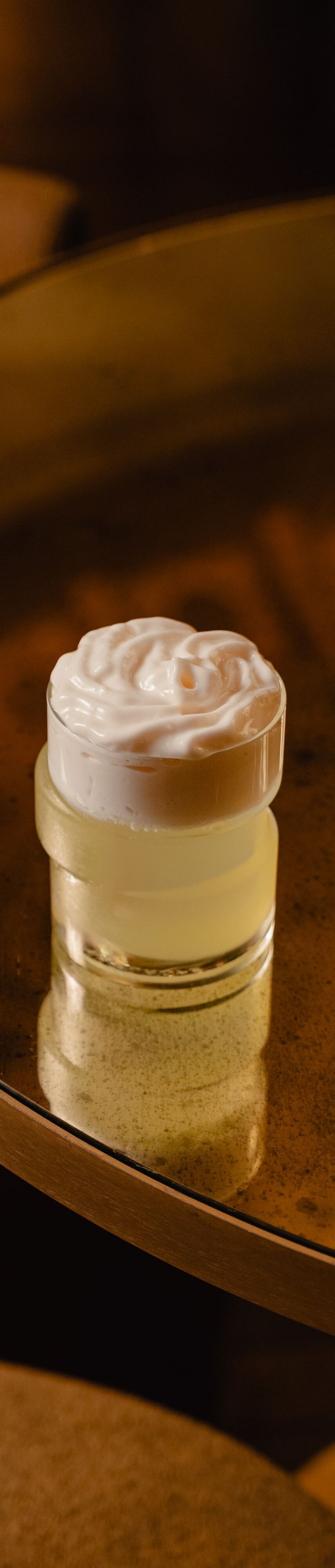Cocktail with foam garnish and asymmetric glass