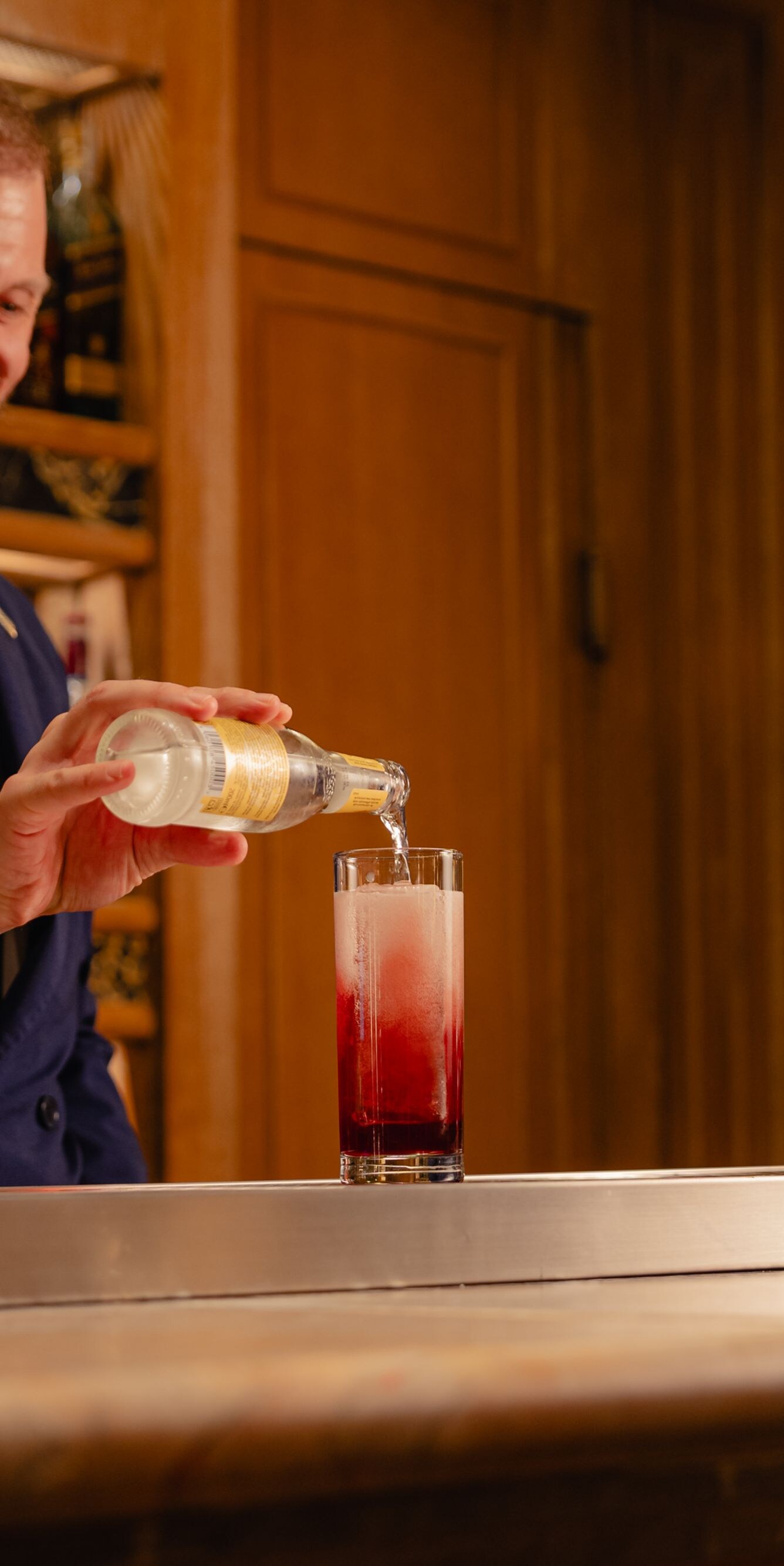 Barista che versa soda a completamento del cocktail