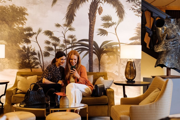 Two women seated in the lobby area and  laughing 