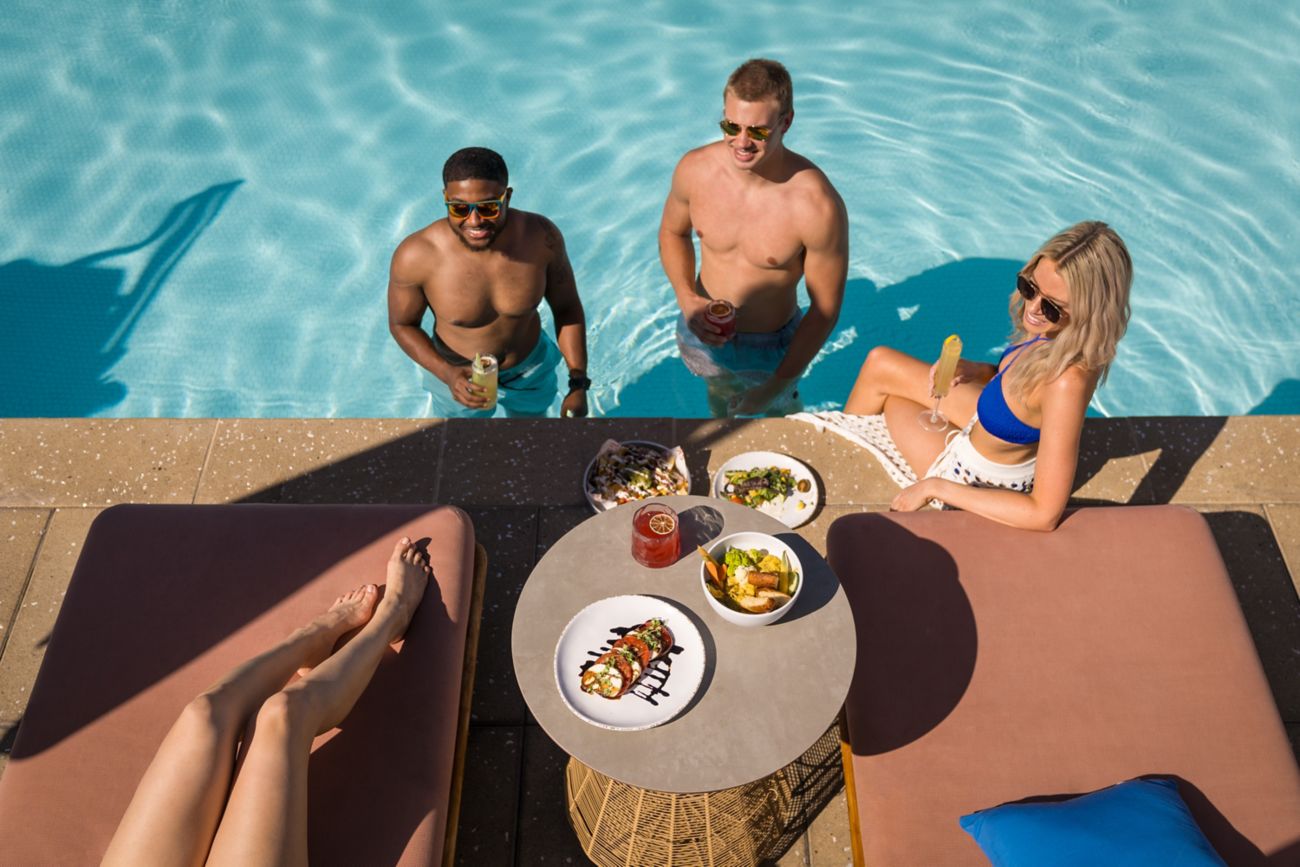 group in pool with food and drinks. 