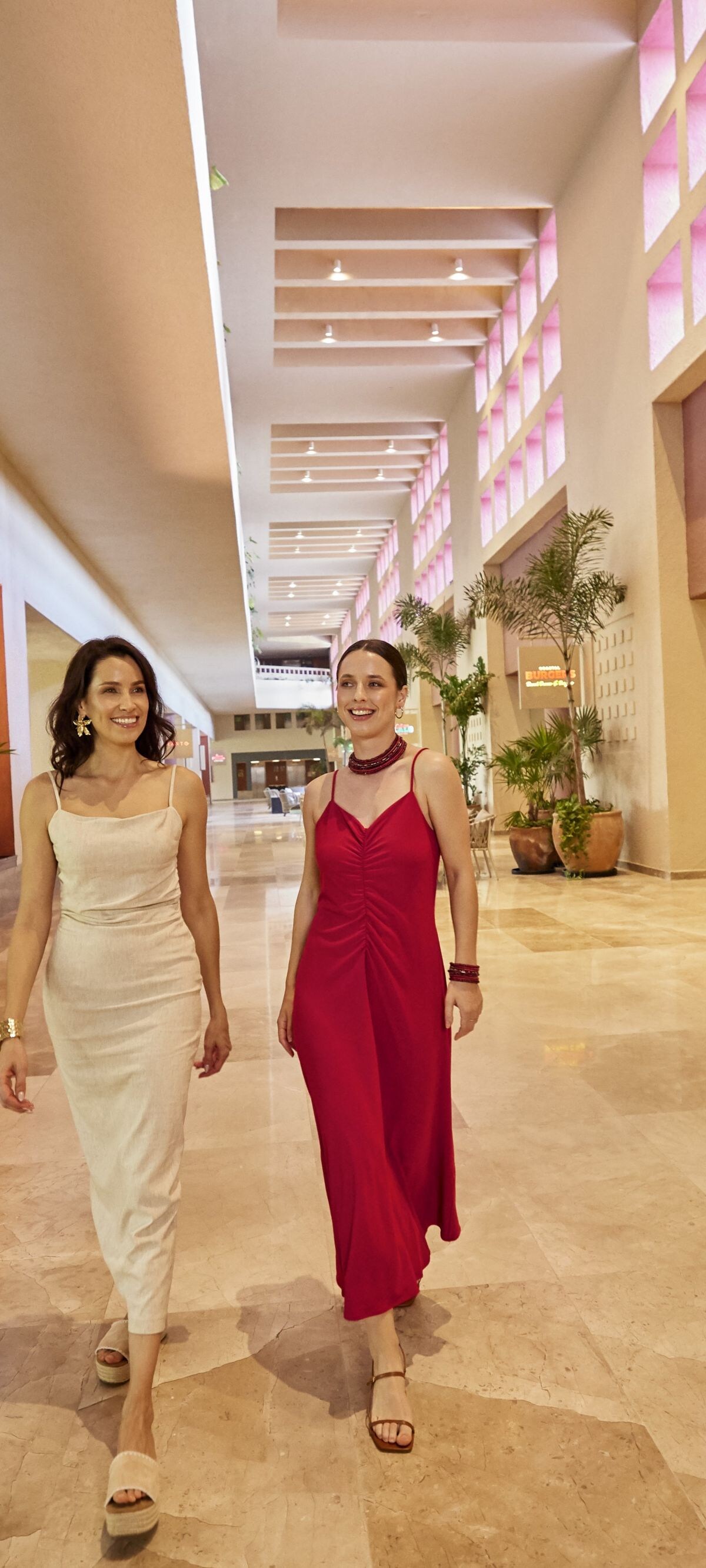 Dos mujeres elegantemente vestidas caminando por un pasillo.