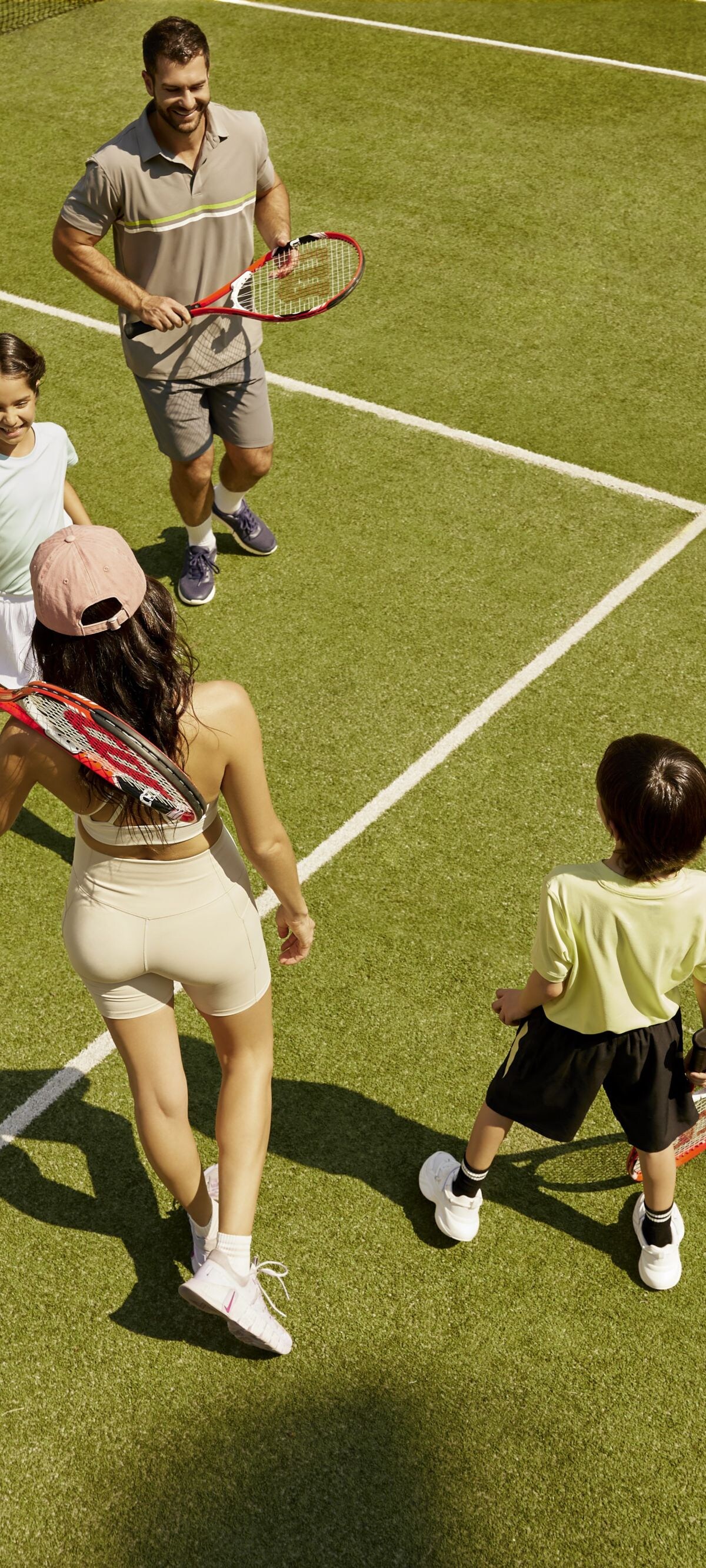 Una familia de cuatro personas en una cancha de tenis.