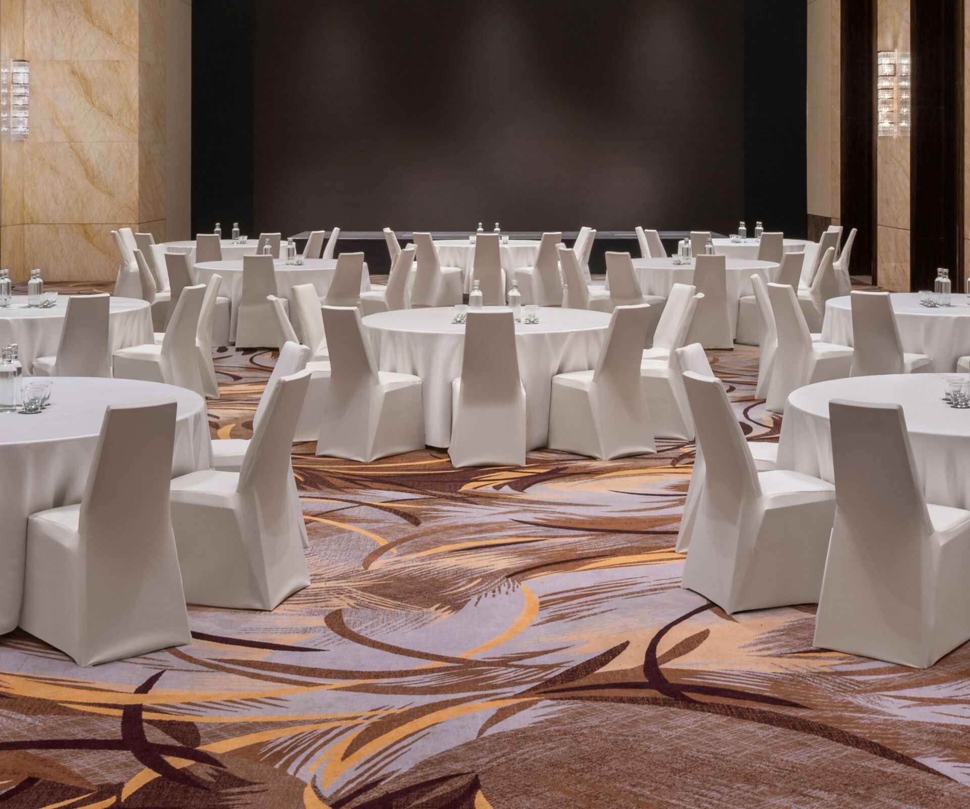 Ballroom meeting setup with white banquet tables