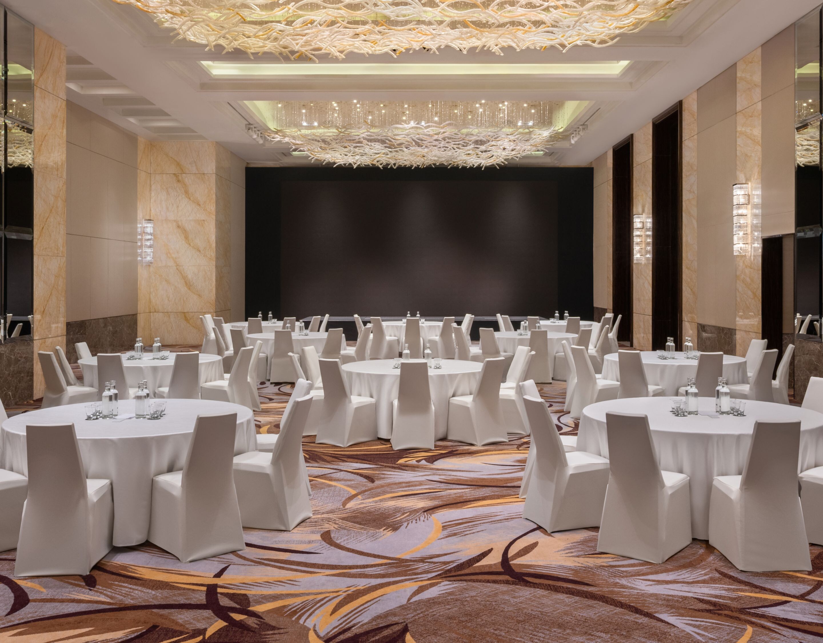 Ballroom meeting setup with white banquet tables