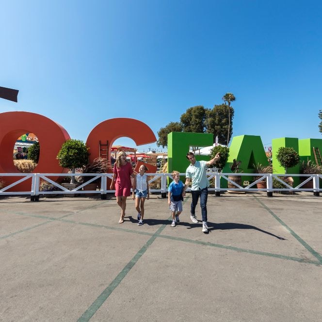 Family posing for a photo in front of the OC Fair sign
