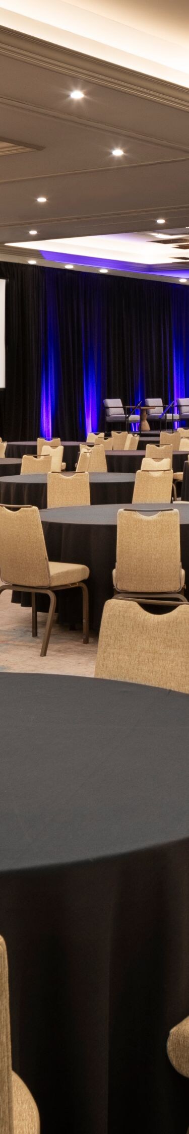 Grand ballroom set with round tables and stage