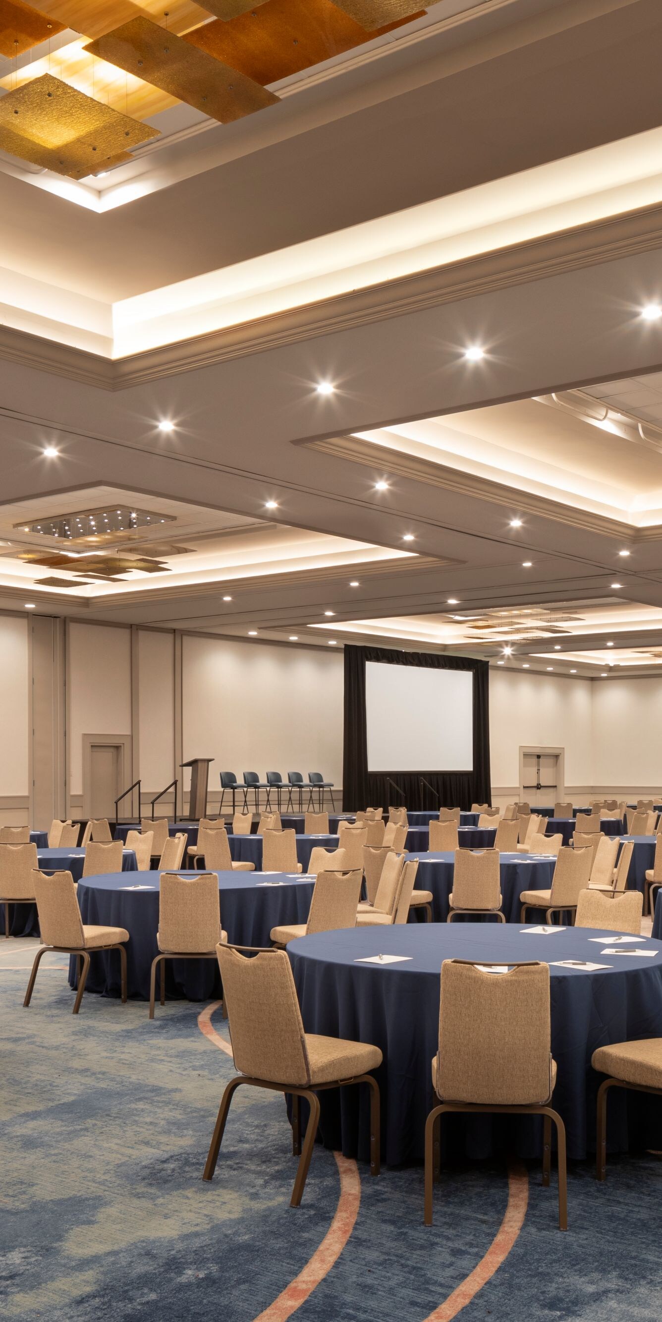 Ballroom set with round tables and presentation sc