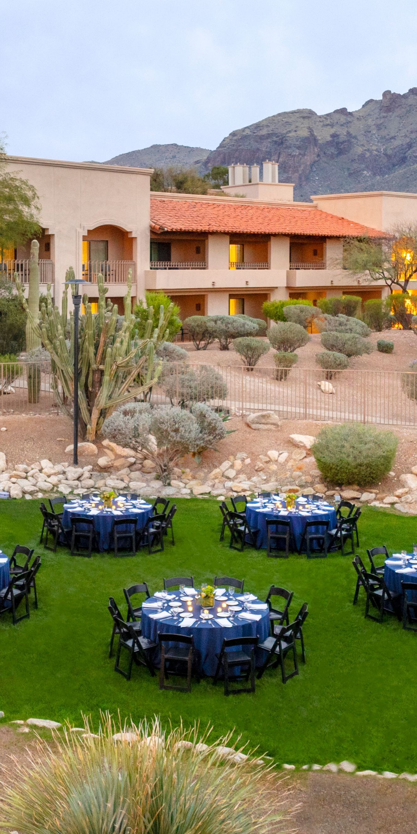 Outdoor lawn dining setup with resort buildings