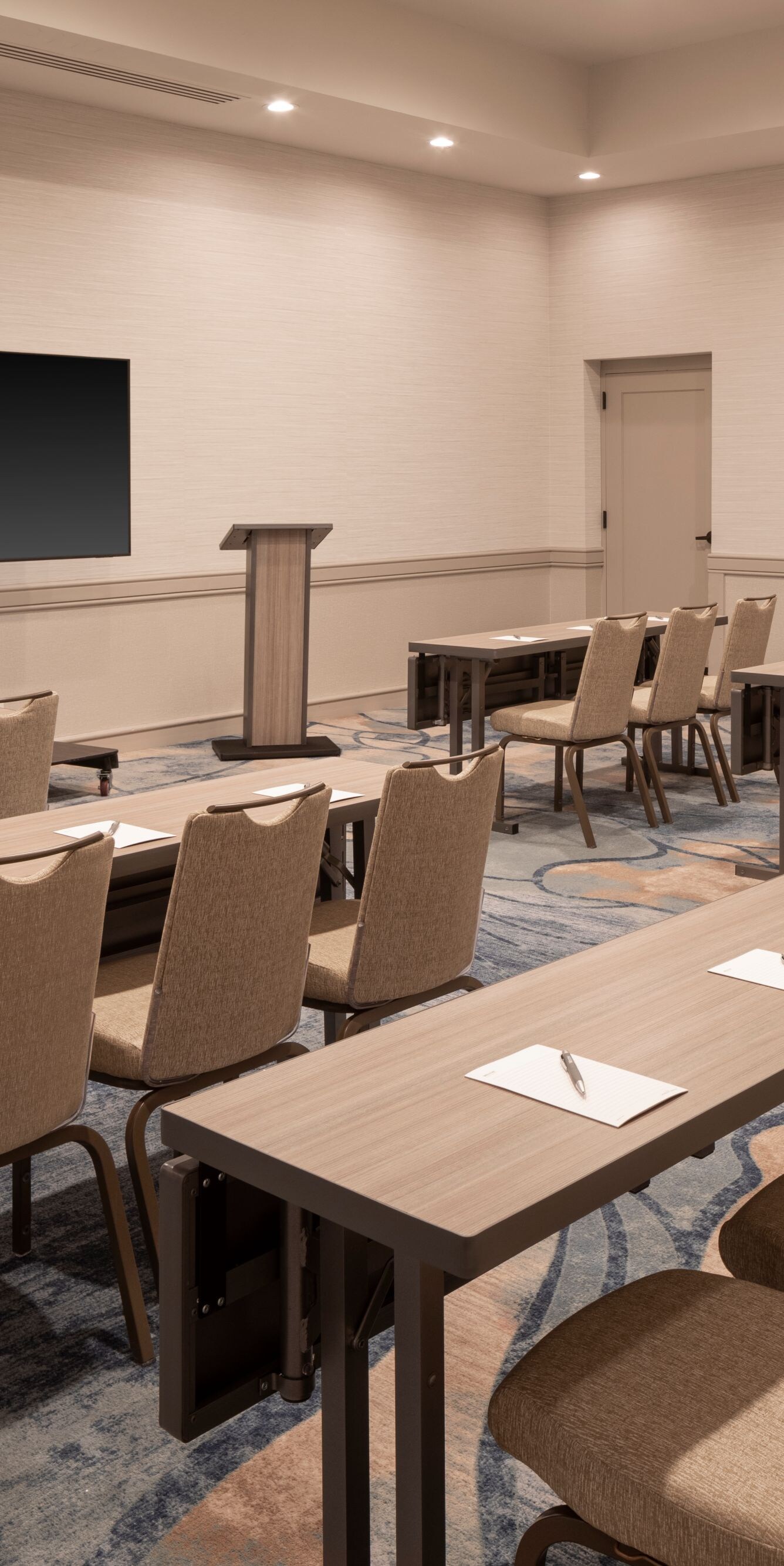 Classroom‑style meeting room with lectern, screen