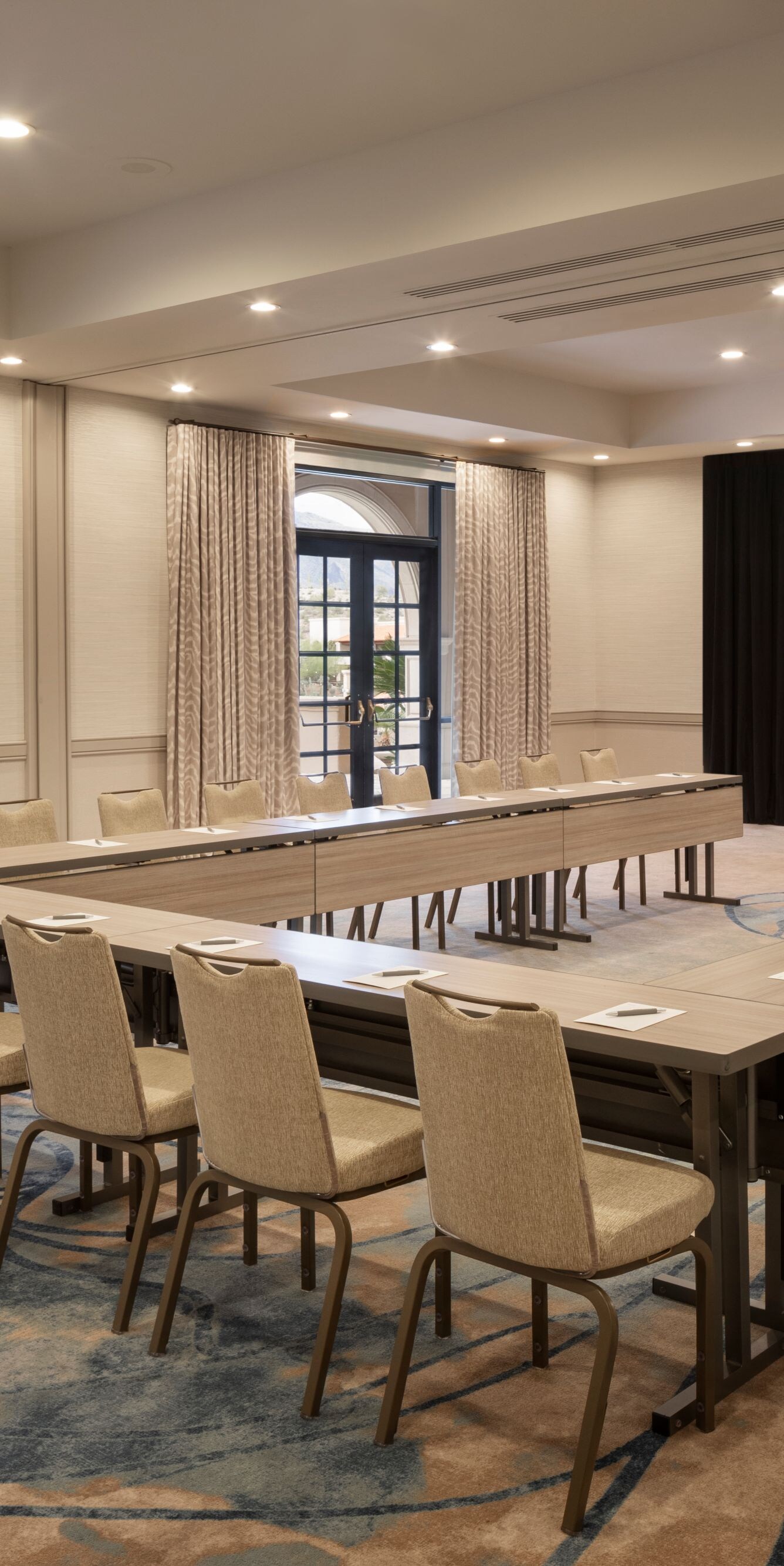 U‑shaped meeting room with tables and presentation